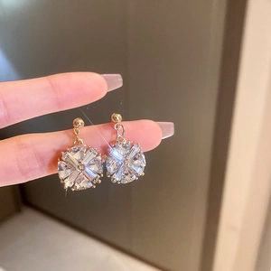 Vue macro détaillée de boucles d'oreilles fleurs dorées avec cristaux de zircon brillants