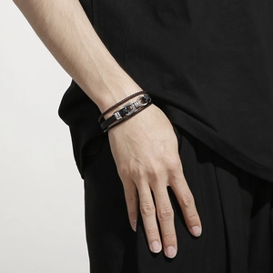 Close-up of a men's multi-layer woven leather bracelet with vintage metal details