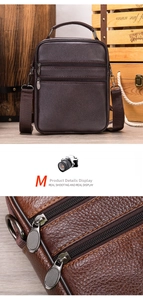 Detailed macro view of brown litchi grain leather texture and metallic dual zippers on bag