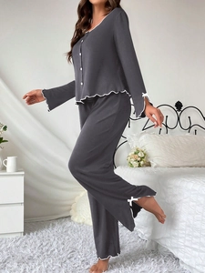 Detail view of the soft ruffled edges and white decorative bows on gray pajama set sleeve