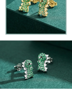 Détails macro des boucles d'oreilles dinosaures avec zircons verts étincelants