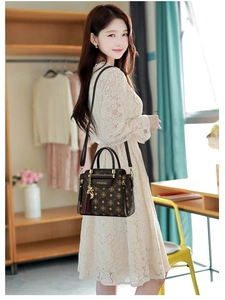 Fashionable dark brown printed handbag with gold hardware styled with a lace dress