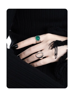 Close-up of wide silver ring with green agate stone on model wearing black knitwear