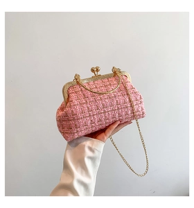 Detailed view of pink tweed small crossbody bag with gold metal frame and chain strap