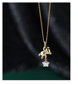 Macro detail of golden bear pendant necklace with a colorful iridescent star stone