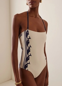 Detail of elegant halter one-piece swimsuit with blue wave patterns on cream fabric