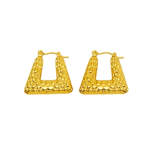 Macro view of golden trapezoid earrings featuring hammered crocodile texture surface