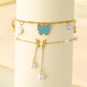 Double-layered gold anklet with blue butterfly pendant, white pearls, and tassel charms