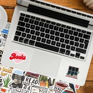 Detail of waterproof reading-themed stickers applied on a laptop with book motifs