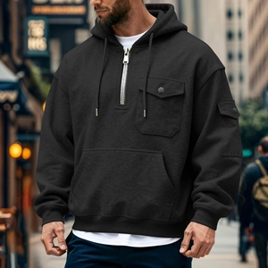 Detalle de sudadera negra con cremallera 1/4, multibolsillos y capucha con cordón ajustable