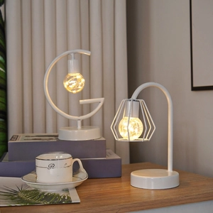 Detail of crescent and geometric iron lamps with warm LED wire lights on wooden desk