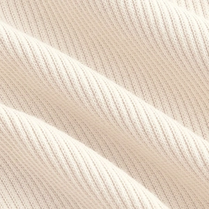 Vista macro del tejido de punto acanalado crema con suaves pliegues y detalles