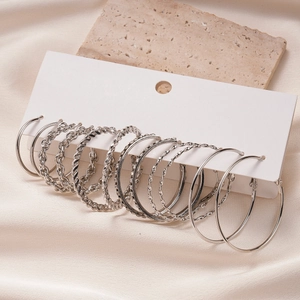 Macro detail of silver geometric hoop earrings set with crystal rhinestones on silk