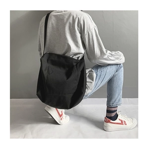 Detail of the oversized black canvas crossbody bag showing texture and slouchy design