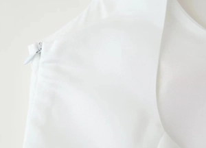 Détail de la fermeture éclair invisible latérale et de la texture du tissu blanc