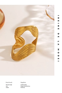 Detailed view of modern matte gold wavy bangle with artistic fluid lines and cutouts