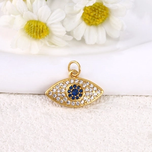 Macro shot of gold-plated evil eye pendant with blue and white cubic zirconia crystals