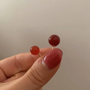 Pair of minimalist 925 silver stud earrings with red agate round spheres in hand