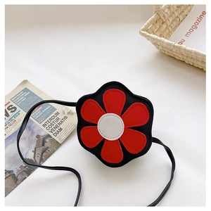 Detail view of a cute flower-shaped kids crossbody bag with red and black leather contrast