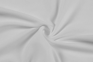 Close-up of high-quality white lace fabric texture with elegant pleated spiral detail