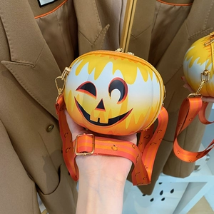 Detail of pumpkin-shaped crossbody bag with a smiling face and adjustable strap