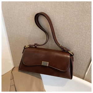 Detailansicht der braunen Leder-Achseltasche mit Metallschnalle und glatter Textur