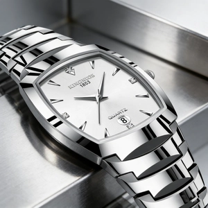 Macro shot of silver quartz watch face with square white dial and date display at 6 o'clock