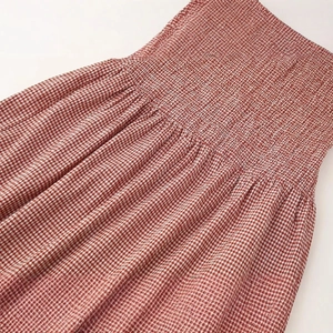 Robe à carreaux rouge et blanc avec détails smockés élégants et tissu en coton respirant
