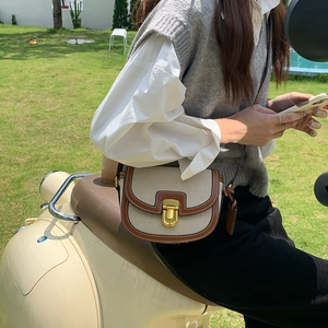 Scatto lifestyle di una borsa a sella in tela e pelle a contrasto indossata da un ciclista
