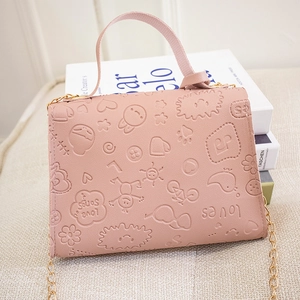 Detailed view of pink leather bag featuring cartoon embossing and a gold chain strap