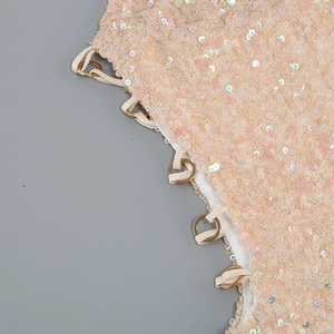 Detail of peach sequin dress showing metallic rings and textured circular sequins