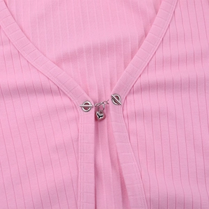 Détail de la boucle métallique en forme de cœur argenté sur cardigan rose côtelé