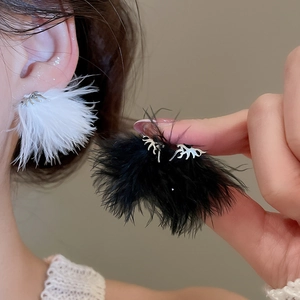Dettaglio di orecchini a piuma creativi in nero e bianco con ganci ad ago d'argento