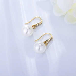 Detail of 925 silver pearl drop earrings with gold hooks and micro-set diamonds