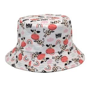 Close-up of cotton bucket hat with cartoon cow prints and rainbow pattern with MOO text