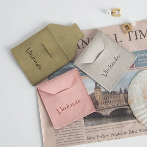 Detalle de bolsas de microfibra para joyas en verde, gris y rosa con textura de terciopelo