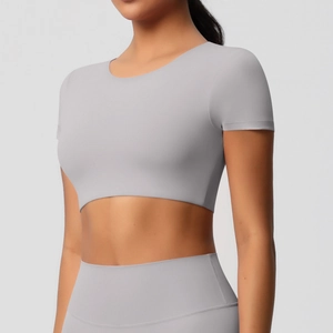Détail d'un ensemble de yoga gris clair avec haut court et leggings de sport taille haute