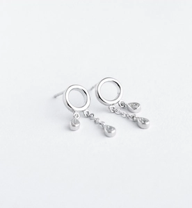 Close-up of silver drop earrings with circular hoop and zircon waterdrop tassel detail