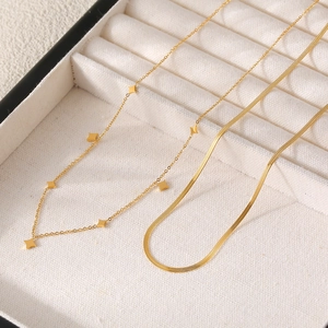 Halskette mit Sternanhängern und Schlangenkette aus Gold-Titanstahl in einer Schmuckschachtel