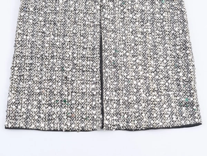 Close-up of sequin embroidery and tweed texture on a sleeveless commuter dress
