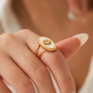 Detail shot of vintage gold-plated sun ring with white shell inlay on model hand