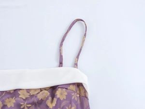 Close-up of purple jacquard dress fabric with gold floral patterns and white collar detail