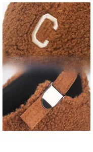 Detail of plush brown baseball cap featuring towel embroidered C logo and metal buckle
