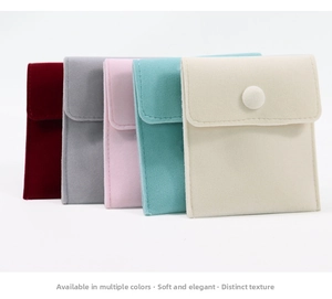 Detailed view of velvet jewelry pouches in multiple colors with elegant snap button closures