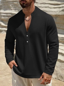 Detail of black henley shirt with mandarin collar and white buttons on textured fabric