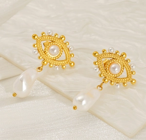 Detail of 18K gold evil eye earrings with white baroque pearl pendants and metal texture