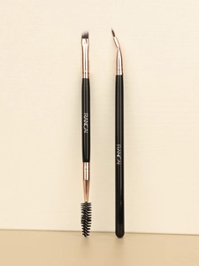 Detailed view of dual-ended eyebrow brush and angled eyeliner brush with synthetic fiber bristles