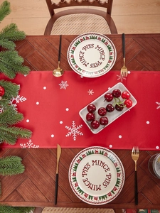 Close-up of festive red linen table runner with white snowflake print for Christmas decor