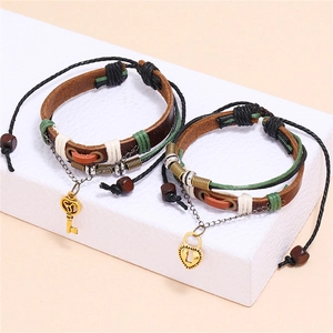 Braided leather couple bracelets with gold heart lock and key charms on display
