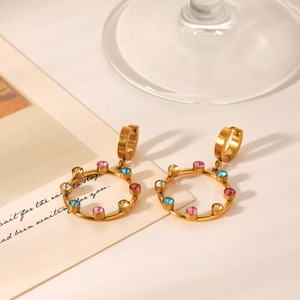 Gros plan détaillé des boucles d'oreilles créoles dorées 18K avec cristaux colorés